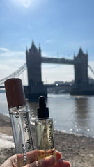An image of Quiet Force Face Oil and Strong Whisper Face Mist in front of the London Bridge